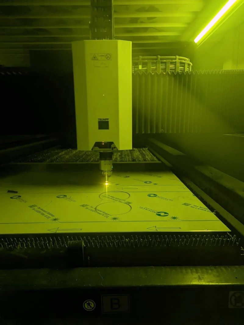 TRUMPF-Schneidkopf beim Laserzuschnitt einer Blechtafel mit Schutzfolie